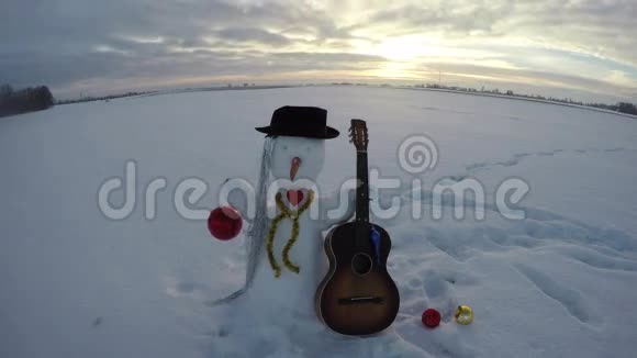 带着吉他和圣诞装饰的雪人时光流逝4K视频的预览图