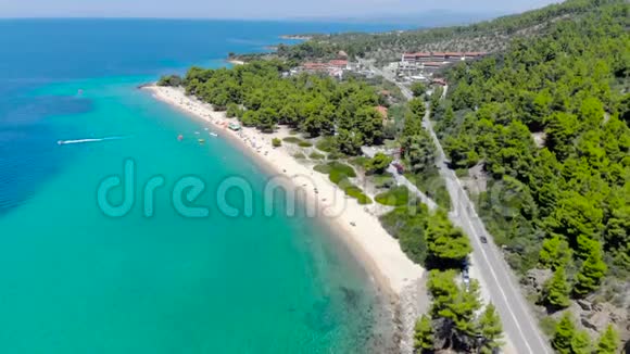 空中无人机在沙滩上看到蓝色的海面周围是树木透明绿松石海洋水面的俯视图视频的预览图