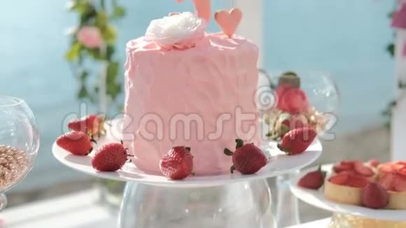 在节日桌上放5号奶油的粉色大生日蛋糕视频的预览图