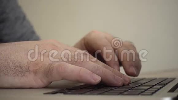 男性手在笔记本电脑键盘上打字视频的预览图