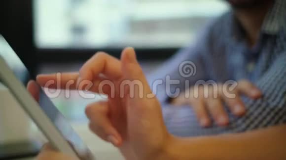 合上她的平板电脑微笑着年轻英俊的商人拿着一杯咖啡和同事们一起工作视频的预览图