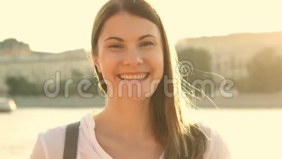 快乐的年轻女子在户外放松的肖像美丽的女孩看着摄像机微笑视频的预览图
