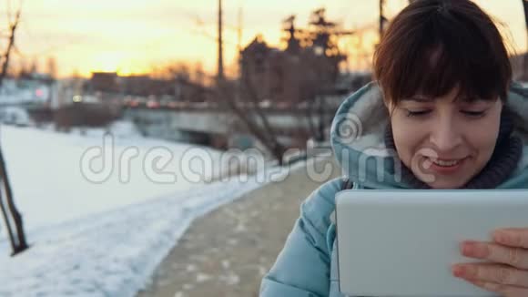 冬天一位年轻女子在户外使用数码平板电脑视频的预览图