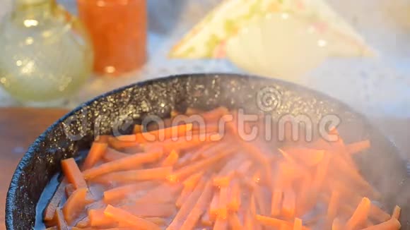 切好的胡萝卜放入铸铁锅中煎蒸汽上升有选择的焦点视频的预览图
