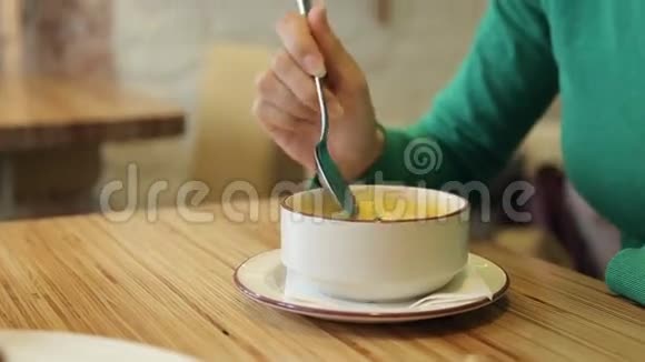 漂亮的女人在咖啡馆里吃美味的汤视频的预览图