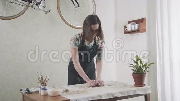 穿着时髦围裙的年轻女子正在从事一个时尚的陶瓷工作室视频的预览图