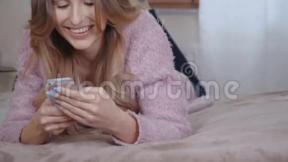 在明亮的卧室里放松的女人在家里读短信视频的预览图