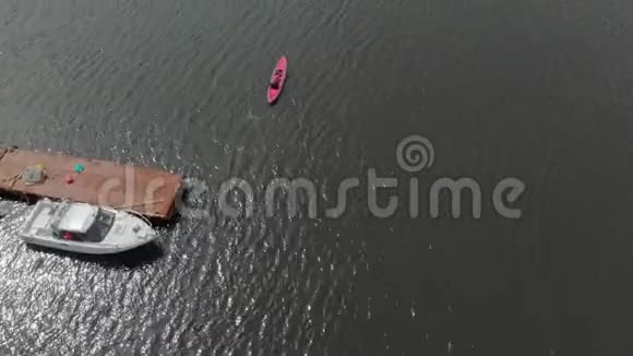 一个年轻人和他的儿子在海中或湖中的充气皮艇上划桨视频的预览图