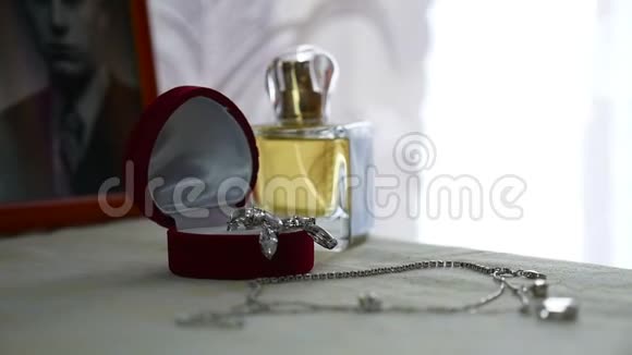 礼品盒中的金戒指耳环带珍珠的项链和女性香水装饰饰品视频的预览图