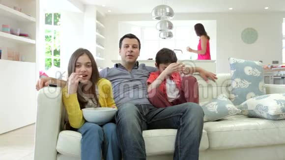 西班牙家庭一起坐在沙发上看电视视频的预览图