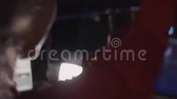 后侧DJ女孩穿红色连衣裙在夜总会转盘旋转跳舞视频的预览图