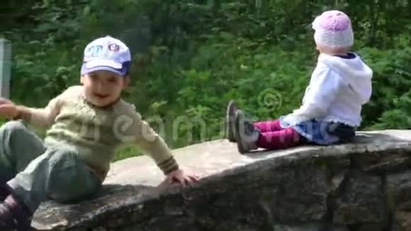 小可爱的男孩和女孩滑下石墙视频的预览图