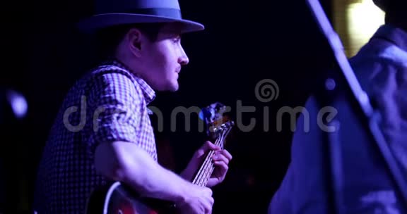 戴帽子的音乐家在夜总会弹吉他关门视频的预览图