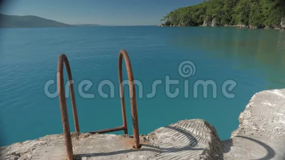 带生锈扶手的浴梯从海上通往陡峭的码头4视频的预览图