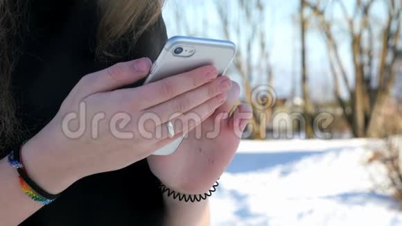 在户外拿着银色智能手机的女生视频的预览图