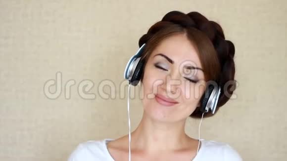 戴着耳机的女人闭着眼睛听着音乐歌曲一个女孩的特写肖像视频的预览图