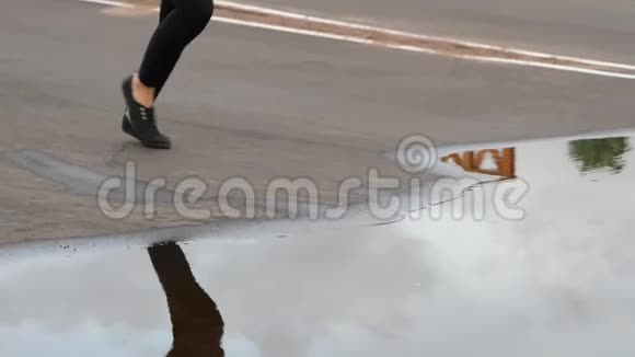 女人的腿在水坑里奔跑跳跃水花飞溅视频的预览图