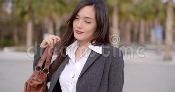 漂亮的年轻女人把钱包放在肩上视频的预览图