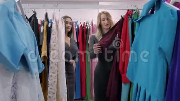 两个幸福的女人在服装店购物选择衣服金发和阿拉伯少女视频的预览图