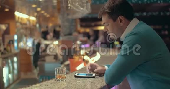 在酒吧里用手机喝酒的人视频的预览图