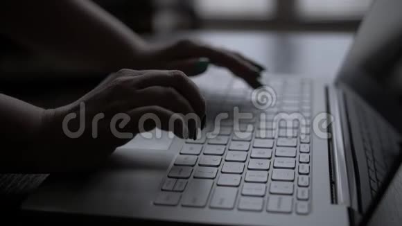 晚上一个女人的手在窗边的笔记本电脑上工作视频的预览图