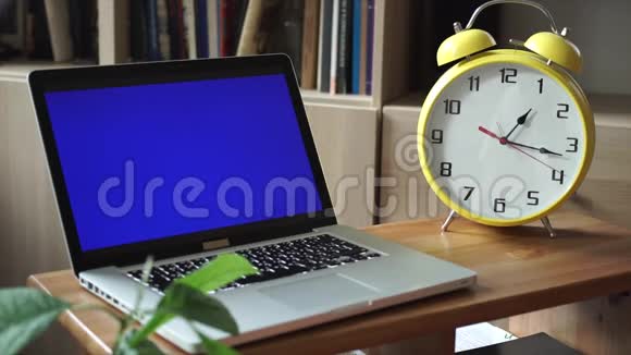 带绿色屏幕的黄色大钟和笔记本电脑视频的预览图