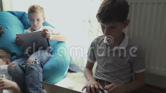 小男孩在家里使用笔记本电脑和平板电脑视频的预览图