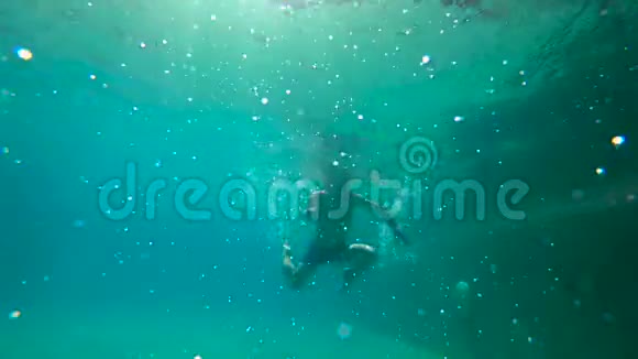 一个小男孩在水下拍摄的超HD慢动作学习如何在游泳池里游泳幼儿男孩潜入游泳池视频的预览图