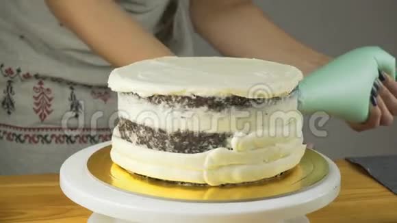 糖果师装饰蛋糕并用黄油霜覆盖它糖果工具对齐奶油的刮刀视频的预览图