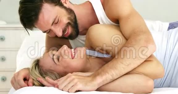 可爱的情侣躺在床上互相拥抱视频的预览图