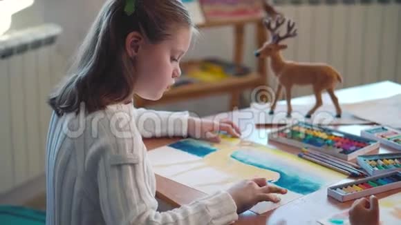 可爱的小女孩在桌子旁画画视频的预览图