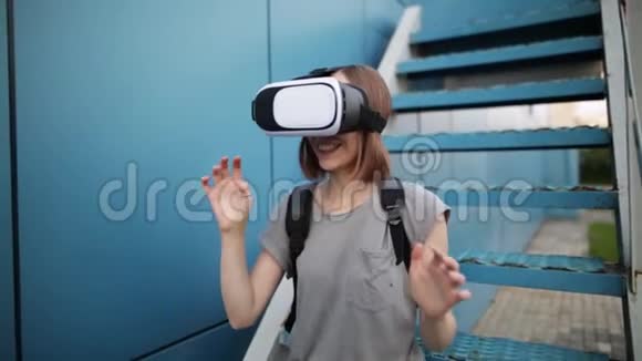 未来就是现在漂亮的年轻女性在楼梯上玩虚拟现实眼镜游戏年轻的白种人女人接触一些东西视频的预览图