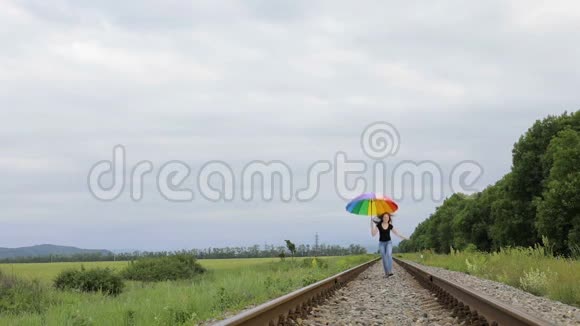 带着雨伞在铁路上跳跃的少女视频的预览图