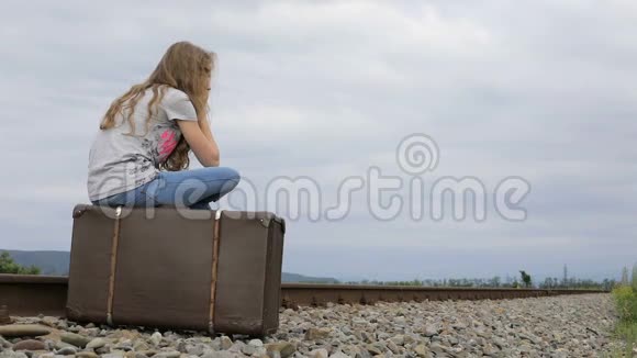 坐在铁路户外的十个年轻悲伤女孩的画像视频的预览图