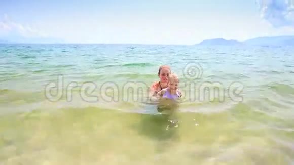 金发小女孩从海里跑到金沙滩视频的预览图