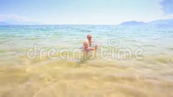 金发小女孩从海里跑到金沙滩视频的预览图
