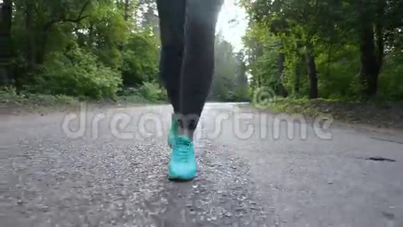 在森林里的路上跑步的女人双脚合拢用安定剂射击视频的预览图