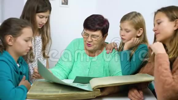 祖母向四个孙女展示旧相册视频的预览图
