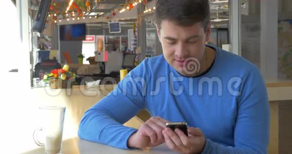 坐在咖啡厅的人带着智能手机视频的预览图