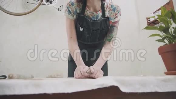 穿着时髦围裙的年轻女子在一间时髦的陶瓷工作室里工作视频的预览图