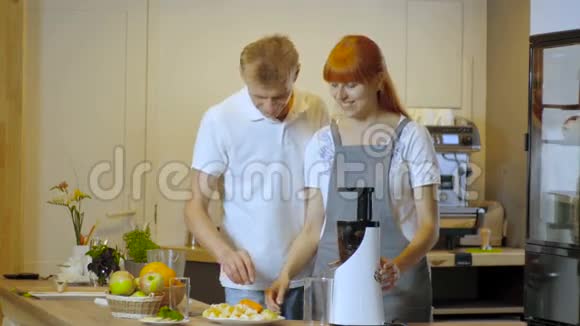 快乐的一对夫妇在厨房里做健康的有机果汁视频的预览图