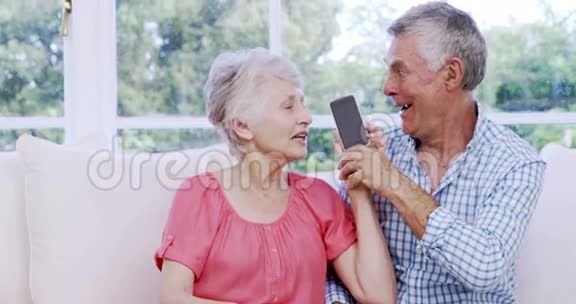 令人惊讶的老年夫妇使用智能手机视频的预览图