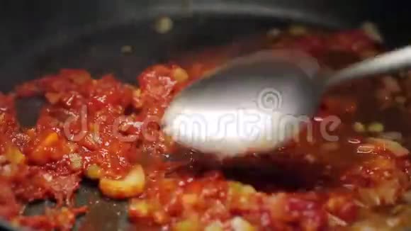 切碎的蔬菜用勺子混合在锅里视频的预览图