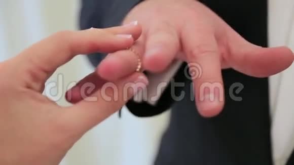 新娘戴在新郎的手指上结婚时戴得很近视频的预览图