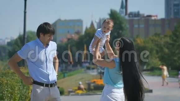 家庭幸福年轻的母亲在天空中抛起婴儿在晴天视频的预览图