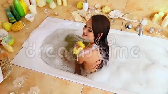 年轻的女人洗泡泡浴顶部视图视频的预览图