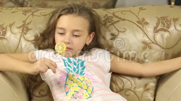 女孩用柠檬的形式在棍子上舔糖果视频的预览图