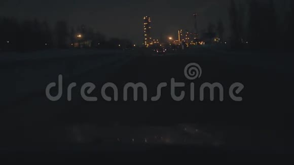 在夜路上开车通过司机挡风玻璃查看分散的城市灯光视频的预览图
