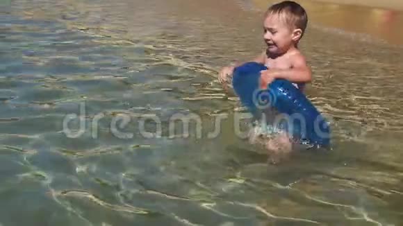 快乐的小男孩在海里飞溅慢动作视频的预览图