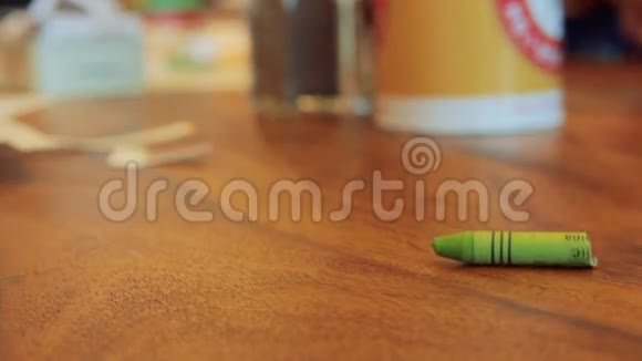 棕色木桌上的绿色彩色蜡笔卷视频的预览图